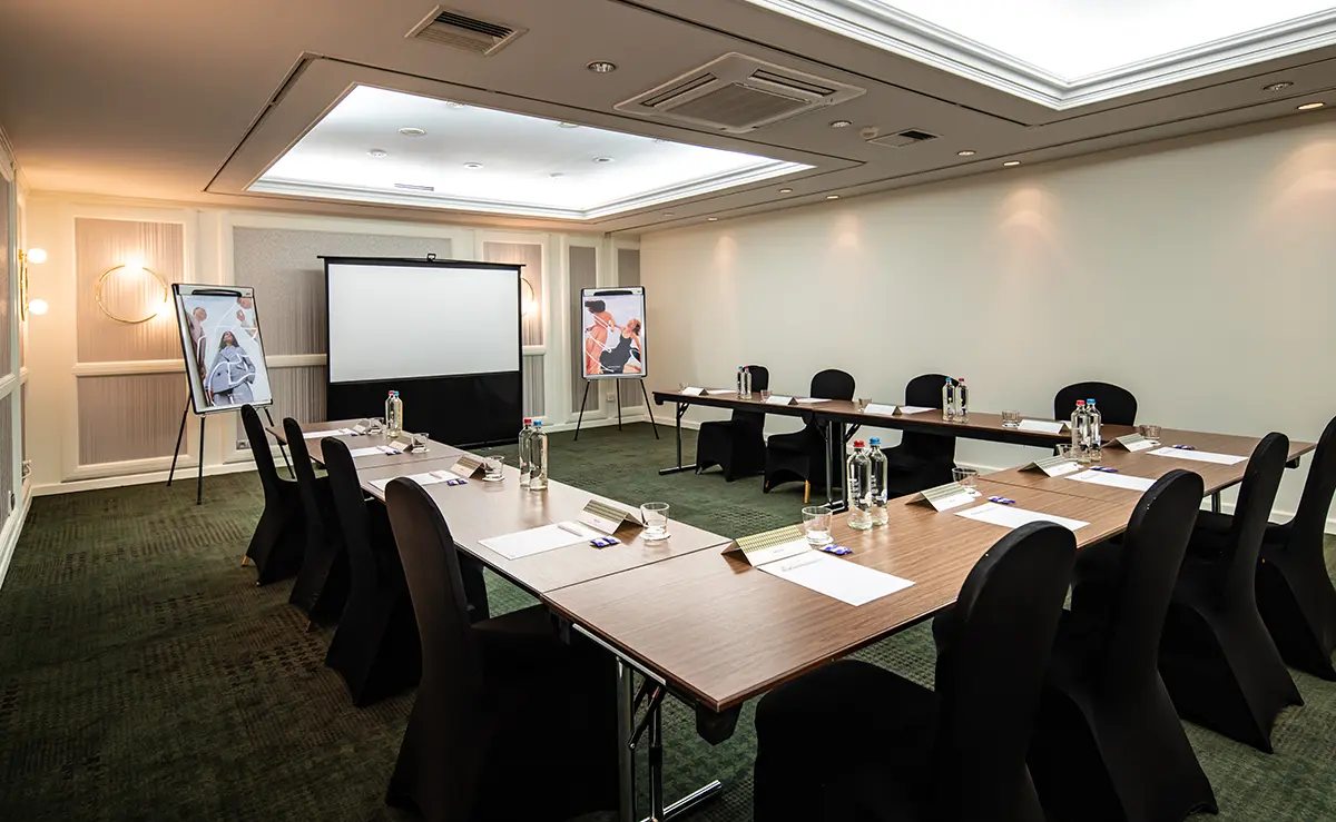 Der Basement Meetingraum mit Tischen und der U-Form und Stühlen rundherum.