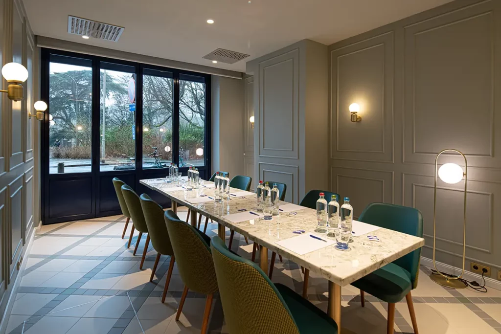 Der Boardroom mit langem Tisch in der Mitte. Auf dem Tisch stehen Wasserflaschen und es liegen Schreibblöcke an jedem Platz.