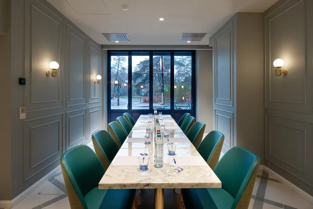 Der Boardroom mit langem Tisch in der Mitte. Auf dem Tisch stehen Wasserflaschen und es liegen Schreibblöcke an jedem Platz.